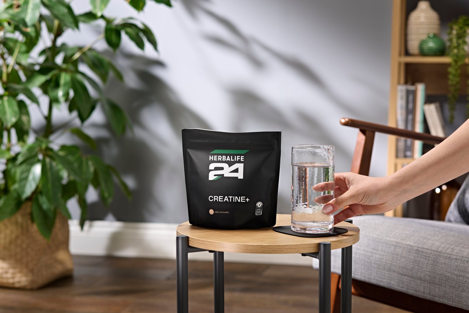 Herbalife24 Creatine+ δίπλα σε ποτήρι νερό σε καθημερινό περιβάλλον